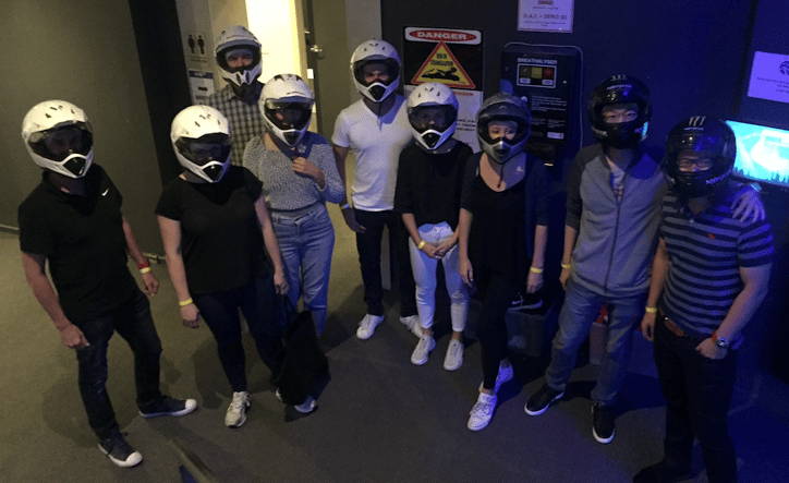 group shot of the direct response media team at the go kart track with their helmets on